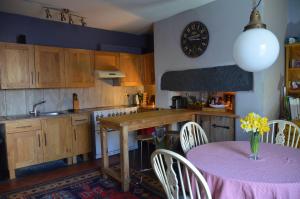 een keuken met een tafel met een roze tafelkleed bij Cynfaen house in Corwen