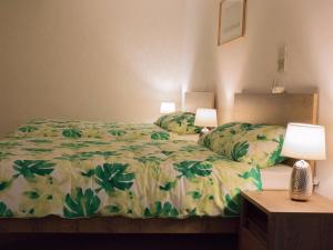 a bedroom with a bed with a green comforter and two lamps at Ioan Budai-Deleanu Apartment in Cluj-Napoca