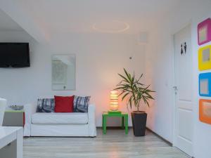 a living room with a white couch and a lamp at Ioan Budai-Deleanu Apartment in Cluj-Napoca