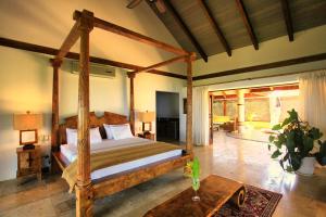 1 dormitorio con cama de madera con dosel en una habitación en Villa Nimbu, en Mal País