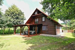 a large wooden house with a large deck at Marcell vendégház in Jósvafő