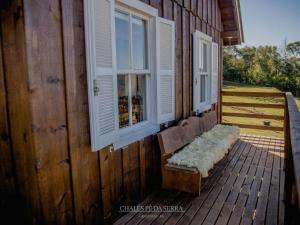 a wooden bench sitting on top of a wooden deck at Chales Pe da Serra in Gramado