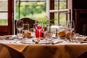 una mesa con copas de vino y platos en ella en Hotel Fief De Liboichant, en Alle