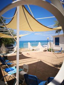 a view of a patio with chairs and an umbrella at Framavi Beach in Cefalù