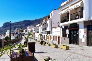 a street in a town with mountains in the background at Apartamentos el Motor Tejeda in Tejeda