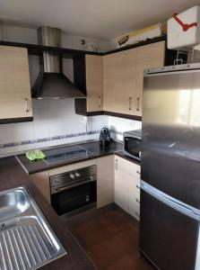 eine Küche mit einem Kühlschrank aus Edelstahl und einer Spüle in der Unterkunft APARTAMENTO ISLANTILLA in Islantilla