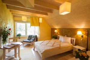 ein Schlafzimmer mit einem Bett und einem Stuhl in einem Zimmer in der Unterkunft Altmõisa Guesthouse in Tuuru