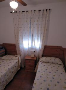 1 Schlafzimmer mit 2 Einzelbetten und einem Fenster in der Unterkunft APARTAMENTO ISLANTILLA in Islantilla