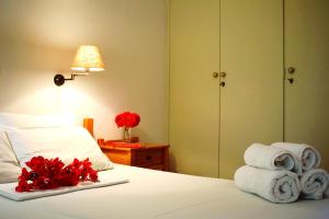 a hotel room with a bed with towels and flowers at Studio Candia in Kandia