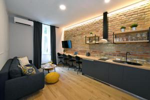 a living room with a couch and a kitchen with a bar at Imperial Apartment, Zagreb City Center West in Zagreb