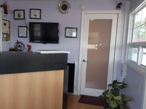 Niagara Inn & Suites في شلالات نياجارا: غرفة معيشة مع تلفزيون بشاشة مسطحة على جدار