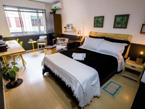 a bedroom with a large bed and a desk at Meu lugar na Cidade Baixa in Porto Alegre