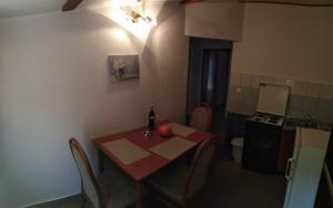 małą kuchnię ze stołem i butelką wina w obiekcie Apartman Rodić w Omišu
