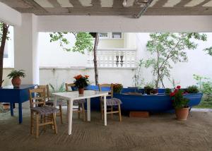 a table and chairs and a blue boat on a patio at Lemonia in Paralia Katerinis