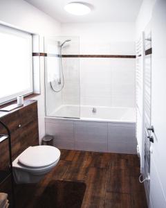 ein Badezimmer mit einem WC und einer Badewanne in der Unterkunft Peter's in Koppl
