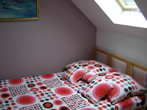 uma cama com lençóis de bolinhas e almofadas num quarto em Apartament Dobra nocka em Krynica-Zdrój