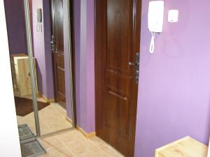 uma casa de banho com paredes roxas e uma porta de madeira em Apartament Dobra nocka em Krynica-Zdrój