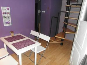 uma mesa e cadeiras num quarto com uma parede roxa em Apartament Dobra nocka em Krynica-Zdrój
