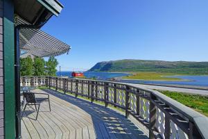 a deck with a chair on the side of a building at Rivdnji Holiday Home Smørfjord in Russenes