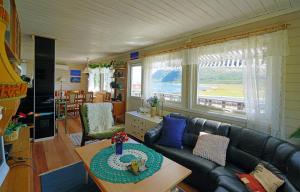 a living room with a couch and a table at Rivdnji Holiday Home Smørfjord in Russenes