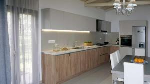 a kitchen with a sink and a refrigerator at Villa Aspasia with private Jacuzzi - Oasis Resort in Kókkinos Pírgos