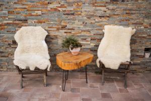 two chairs and a table in front of a brick wall at Tourist Farm Urška in Zreče