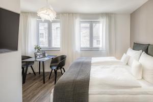 a white bedroom with a bed and a desk at cosy grey apartments in Freiburg im Breisgau