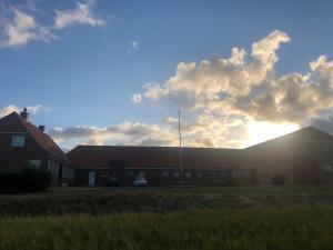 a group of buildings with the sun in the sky at Bjerrumgaard in Ribe