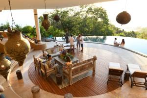 un grupo de personas de pie en una terraza junto a una piscina en Villa Nimbu, en Mal País