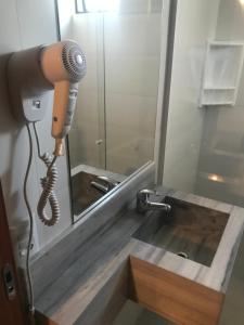 secador de pelo frente al espejo del baño en Hotel Blumenhof Balneário Camboriú, en Balneário Camboriú