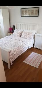 1 dormitorio con cama blanca y suelo de madera en Apartman Nikolina, en Biograd na Moru