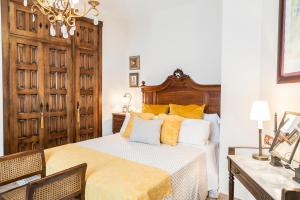 - une chambre avec un lit et une tête de lit en bois dans l'établissement Mafloras Suites El Bosque, à El Bosque