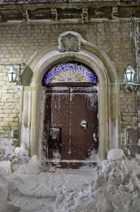 an archway with a wooden door in the snow at Appartamento storico in pieno centro ad Agnone in Agnone