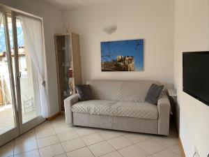 uma sala de estar com um sofá e uma televisão em Appartamento Marina em Arco