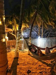 - un homme dormant dans un hamac sur une plage la nuit dans l'établissement The Cantamar Beach Hostel, à Santa Marta