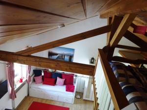 an attic room with a white couch with red pillows at Ferienwohnung Pickert in Bad Endorf