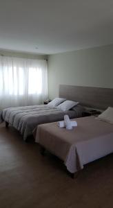 two beds in a hotel room with towels on them at Hotel Amaru Express in Arica