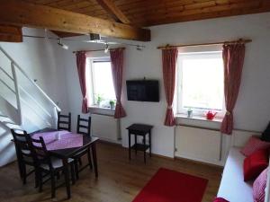 a living room with a table and two windows at Ferienwohnung Pickert in Bad Endorf