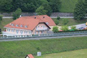 a large house with a red roof on the side of a road at Rooms Hochkraut in Celje