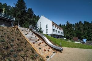 a slide on a hill in front of a building at Hotel Monínec - Depandance Nová Javorka in Moninec +60 photos