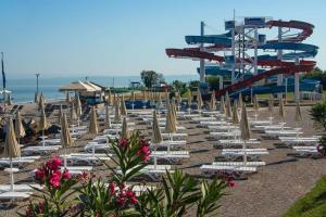 a beach with chairs and a roller coaster at Apartment Sansimon in Izola