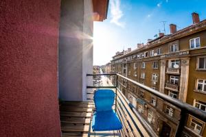 una silla azul sentada en el balcón de un edificio en Sofia Artist Life Apartment, en Sofía
