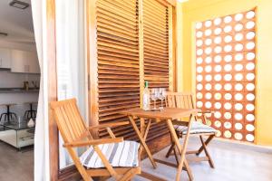 una sala da pranzo con tavolo in legno e 2 sedie di HomeForGuest BEACH APT WITH SEA VIEW & POOL, 50 STEPS TO THE SEA a Playa Fañabe