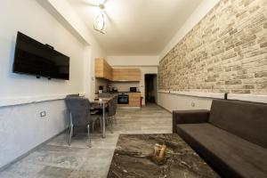 uma sala de estar com um sofá e uma parede de tijolos em Sofia Downtown Life Apartment em Sófia