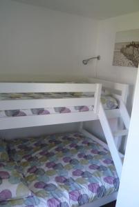 Ce lit superposé blanc se trouve dans un dortoir. dans l'établissement GITE BORD DE MER, à Bernières-sur-Mer