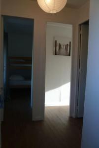 un couloir avec une porte s'ouvrant sur une chambre dans l'établissement GITE BORD DE MER, à Bernières-sur-Mer