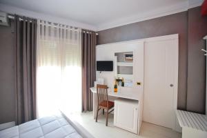 1 dormitorio con 1 cama y escritorio con silla en Iliria Internacional Hotel, en Durrës