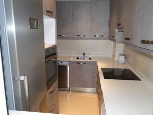 cocina con nevera de acero inoxidable y fregadero en Apartamentos Sitges, en Sitges