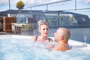 un hombre y una mujer en un jacuzzi en Hotel Viking Aqua Spa & Wellness, en Saeby