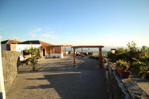 einen Gang mit einem Pavillon neben einem Gebäude in der Unterkunft Villa Las Rosas, Los Menores, Adeje, sea view in Armeñime